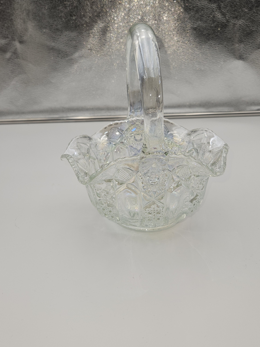 Clear Glass iridescent carnival glass basket features and ruffled rim.